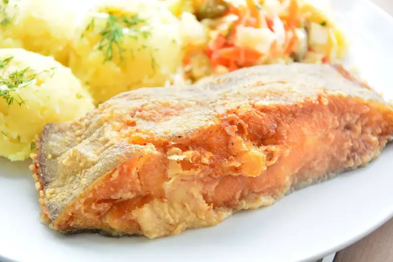 Chrupiący halibut smażony na złoto, podany z puree ziemniaczanym i surówką. Pyszny obiad gotowy!
