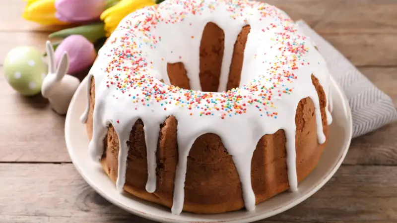 Babka z lukrem i kolorową posypką, ozdobiona wielkanocnymi zajączkami i pisankami, gotowa na święta.